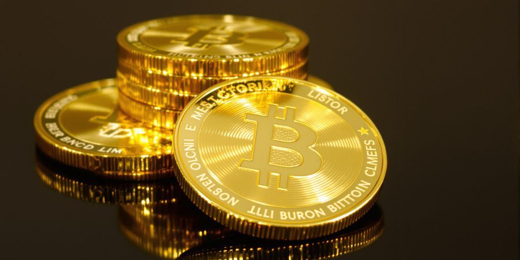 Pièces d'or brillantes empilées sur une surface foncée.