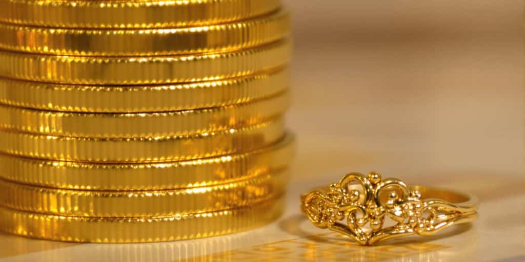 Gros plan sur des pièces et bijoux en or brillants.