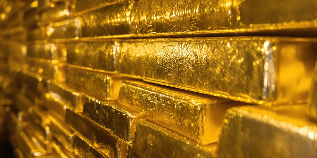 Lingots d'or empilés dans un coffre bancaire sécurisé.
