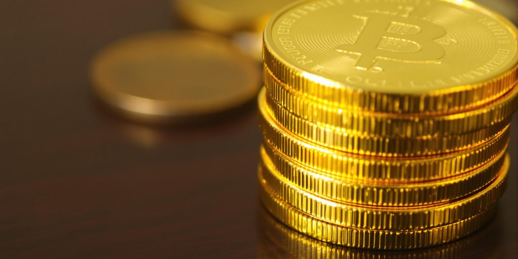 Pièces d'or brillantes empilées sur une table en bois.