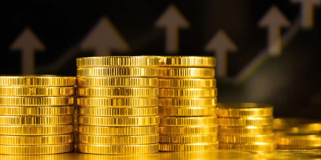 Pièces d'or empilées, flèches inflationnistes.