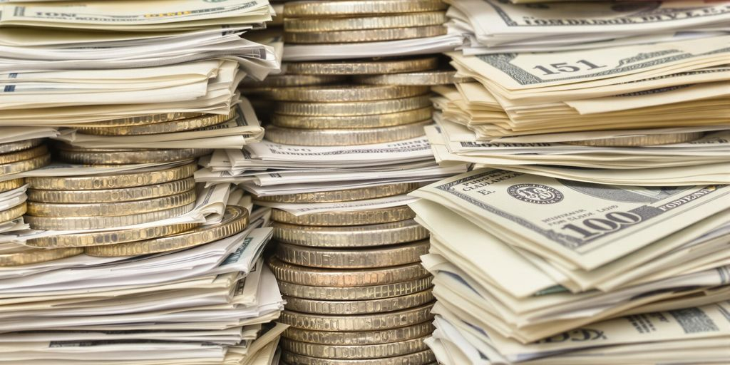 Pièces et billets de banque variés empilés.