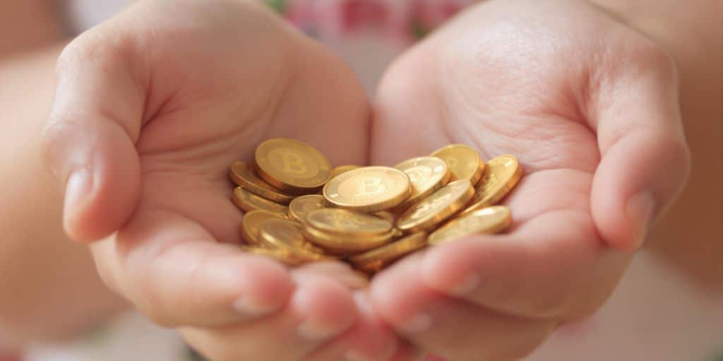 Mains d'enfants saisissant des pièces d'or brillantes