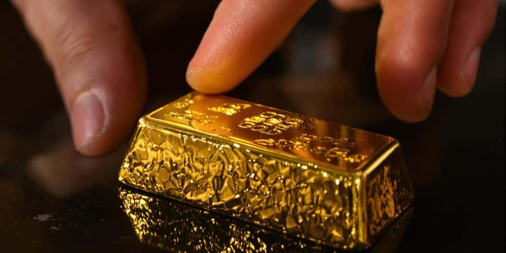 Lingot d'or et mains effectuant une transaction
