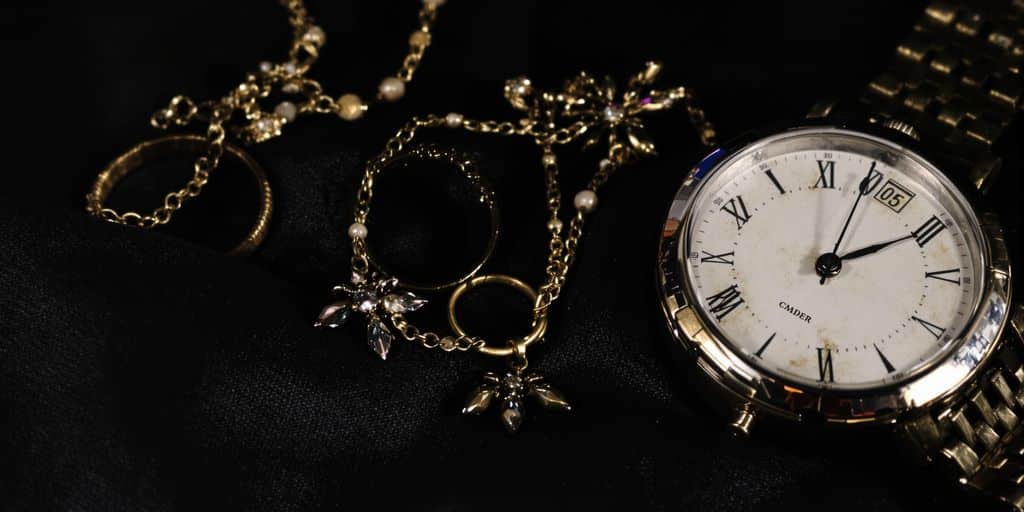 Bague, collier et montre anciens sur tissu sombre
