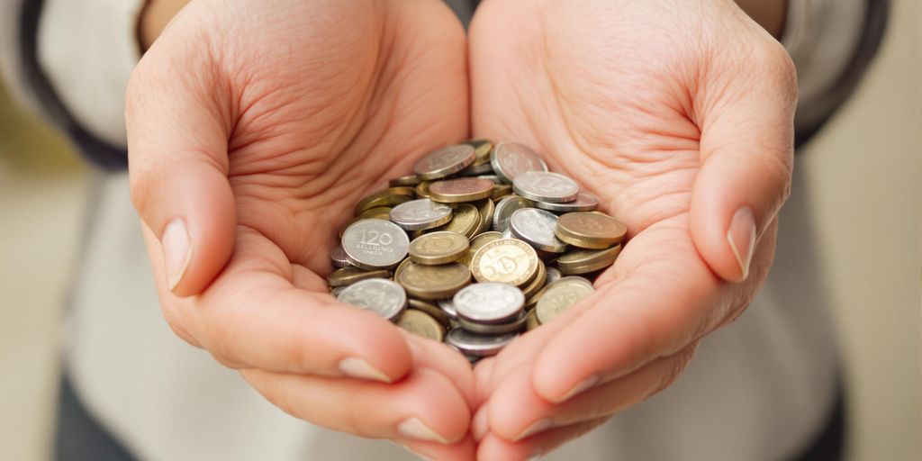 Mains protégeant des pièces de monnaie