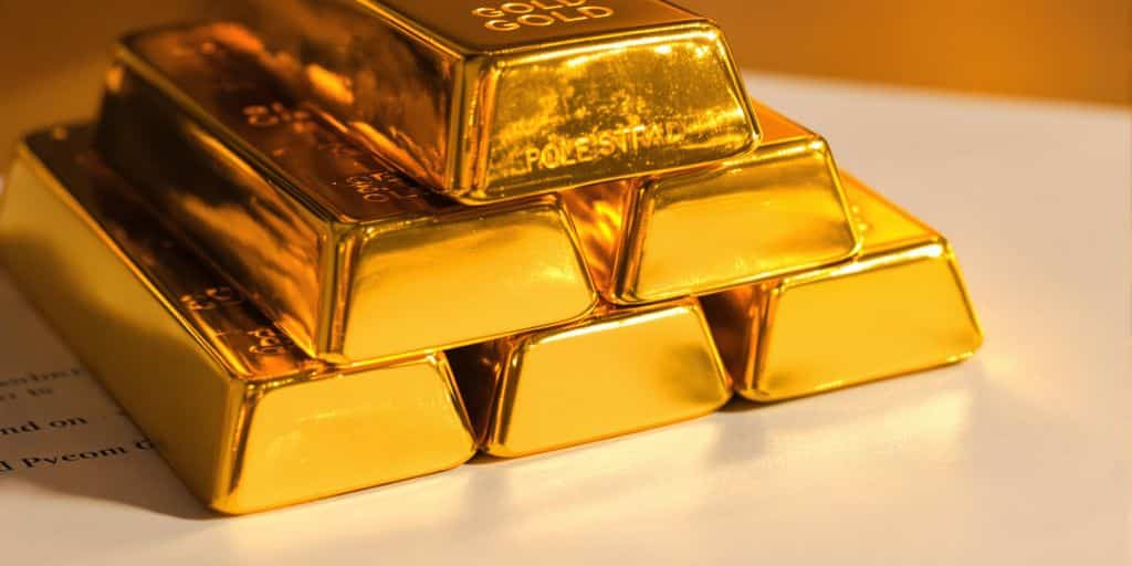 Lingots d'or empilés sur une police d'assurance.