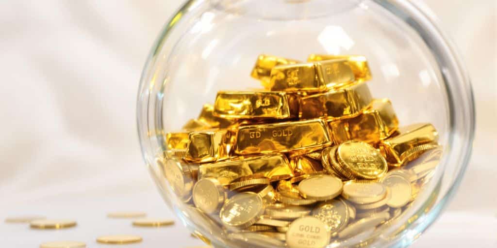 Lingots d'or et pièces dans une tirelire