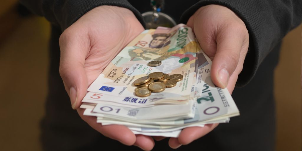 Main tenant des billets et des pièces