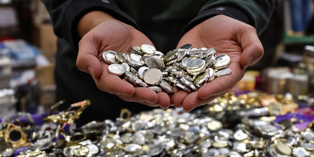 Mains tenant des lingots d'argent sur un étal de foire.