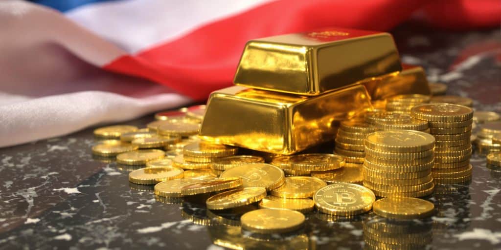 Barres d’or et pièces disposées sur granit avec drapeau flou