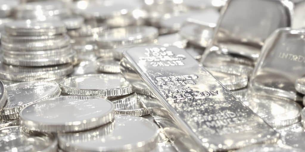 Pièces d'argent brillantes et lingots d'argent empilés