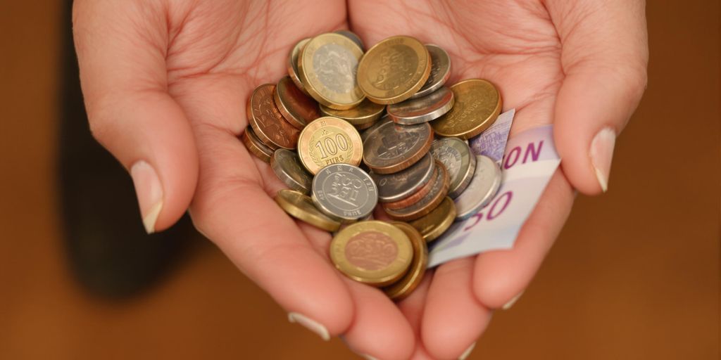 Main tenant des pièces de monnaie et des billets.