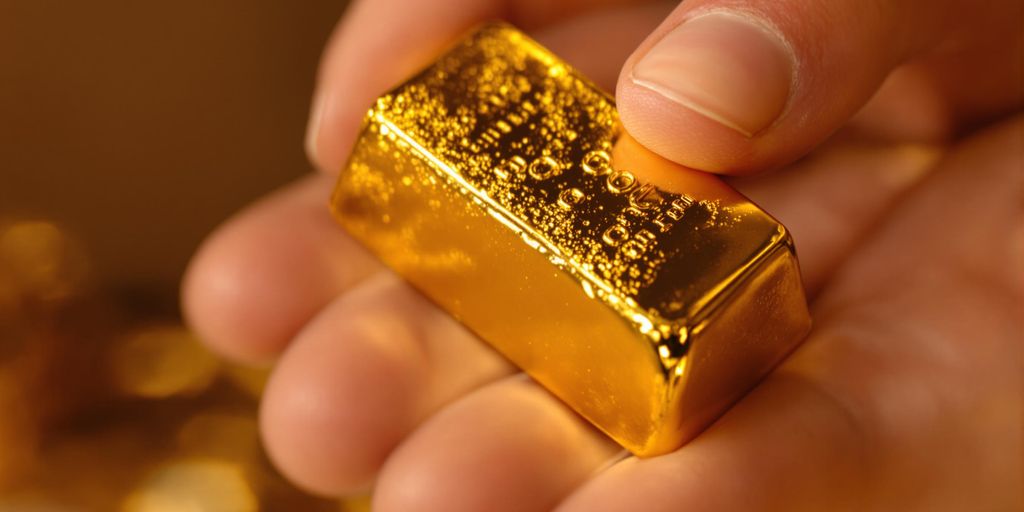 Main tenant un lingot d'or brillant