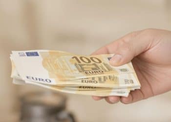 Main tendant des billets de banque