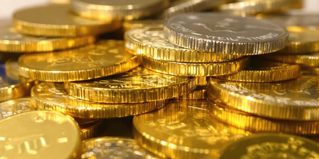Pièces d'or et d'argent empilées sur une carte bancaire.