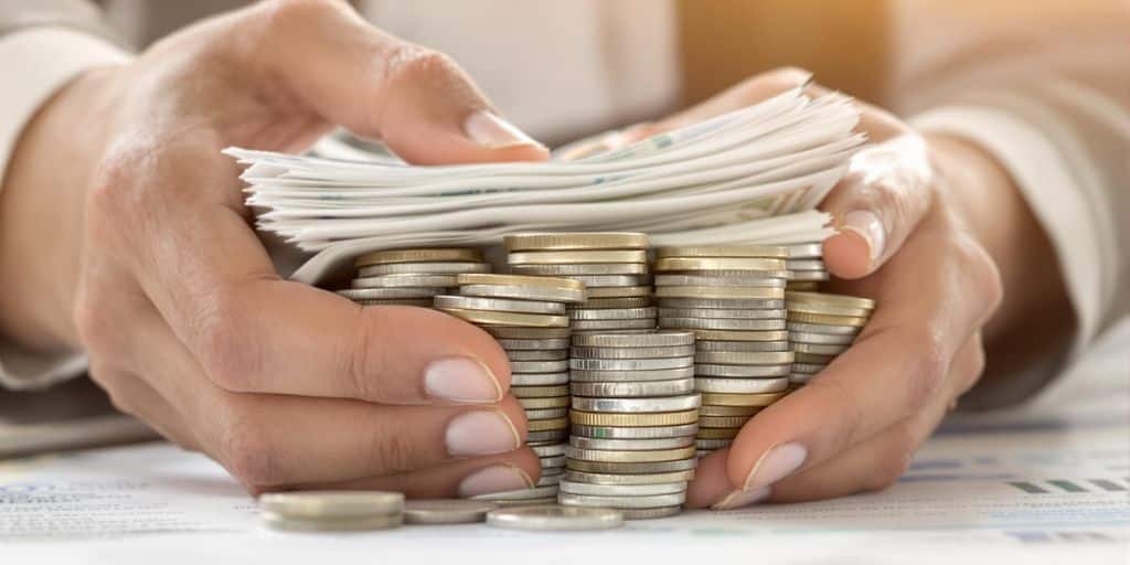 Main tenant des pièces d'argent et des billets