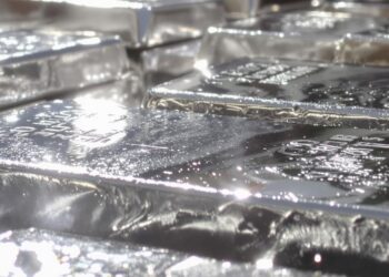 Lingots d'argent et pièces d'or sur une pile.
