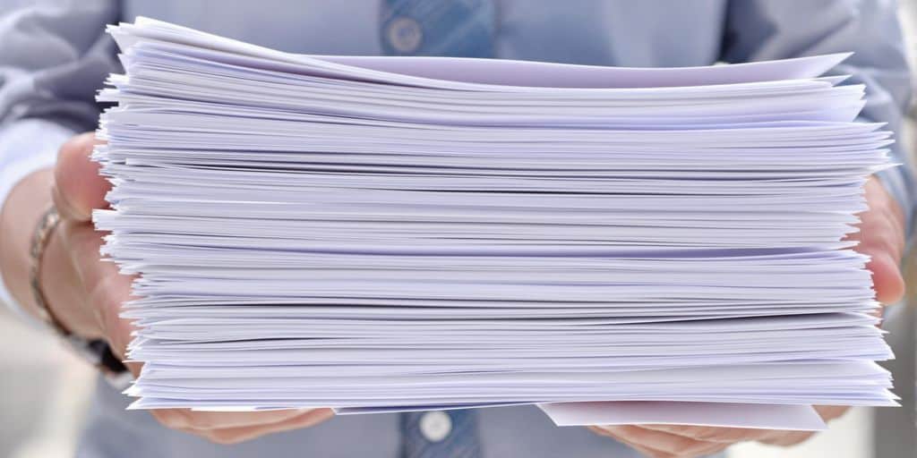 Main tenant une pile de documents officiels