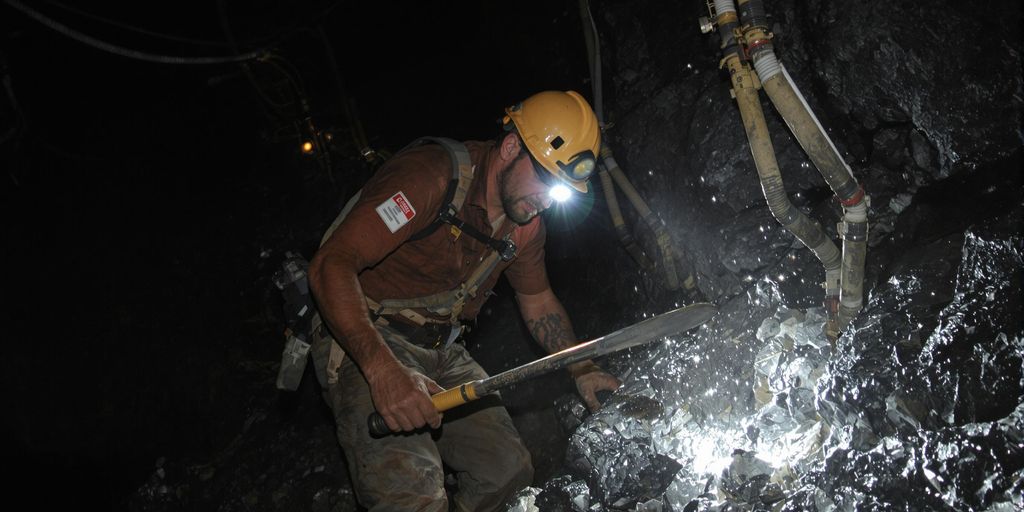 Mineur travaillant, argent brut, coût énergie.