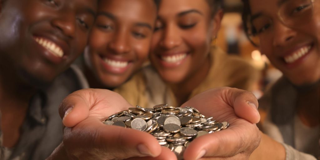 Jeunes souriants regardant des pièces d'argent.