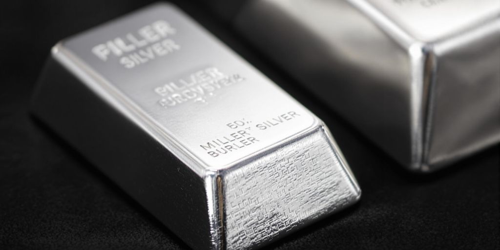 Deux lingots d'argent, petit et grand, sur fond sombre.