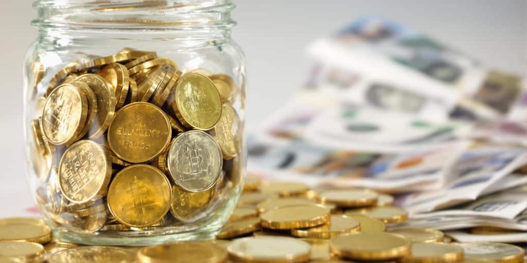 Une tirelire remplie de pièces en or et de billets.
