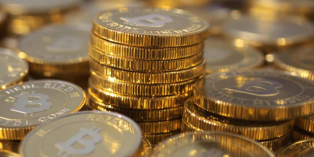 Pièces d'or brillantes empilées sur fond flou.