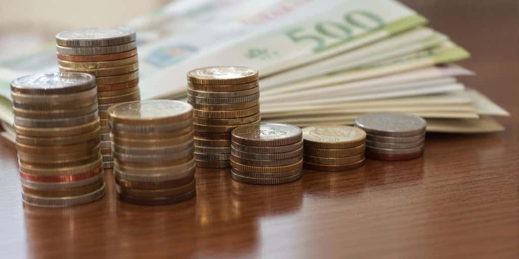 Table avec des piles de pièces et des billets de banque.