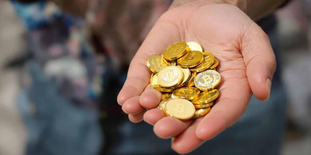 Main tenant une poignée de pièces d'or brillantes
