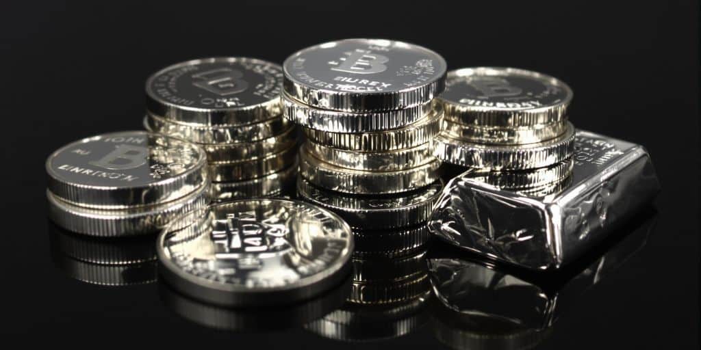 Pièces d'argent brillantes et lingots d'argent empilés