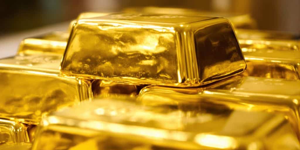 Lingots d'or empilés et pièces d'or brillantes