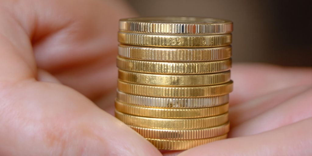 Main tenant une pile de pièces de monnaie