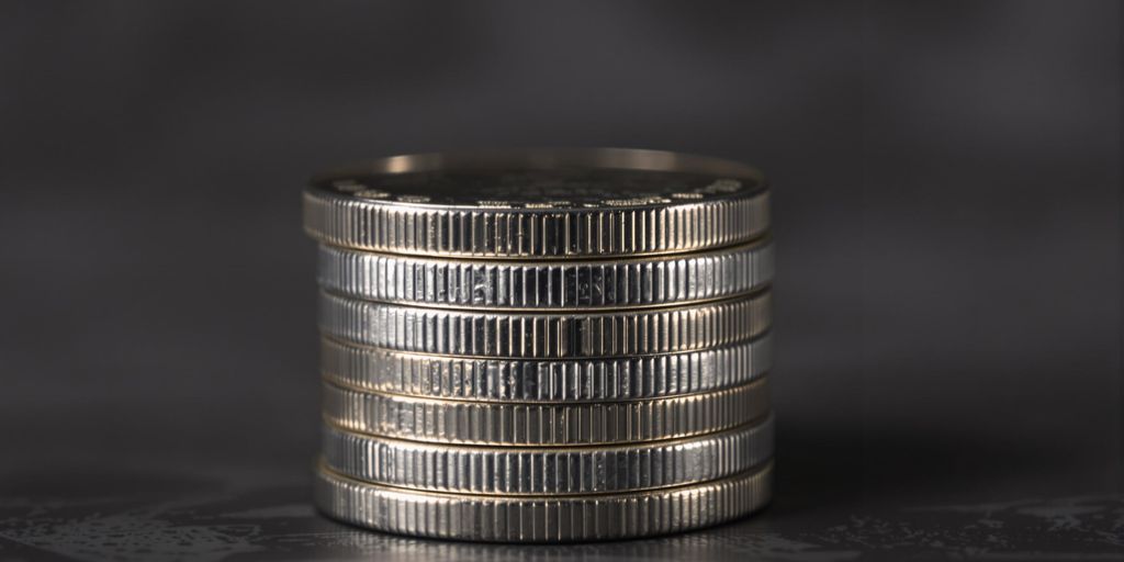 Pièces d'argent brillantes empilées sur une surface foncée.