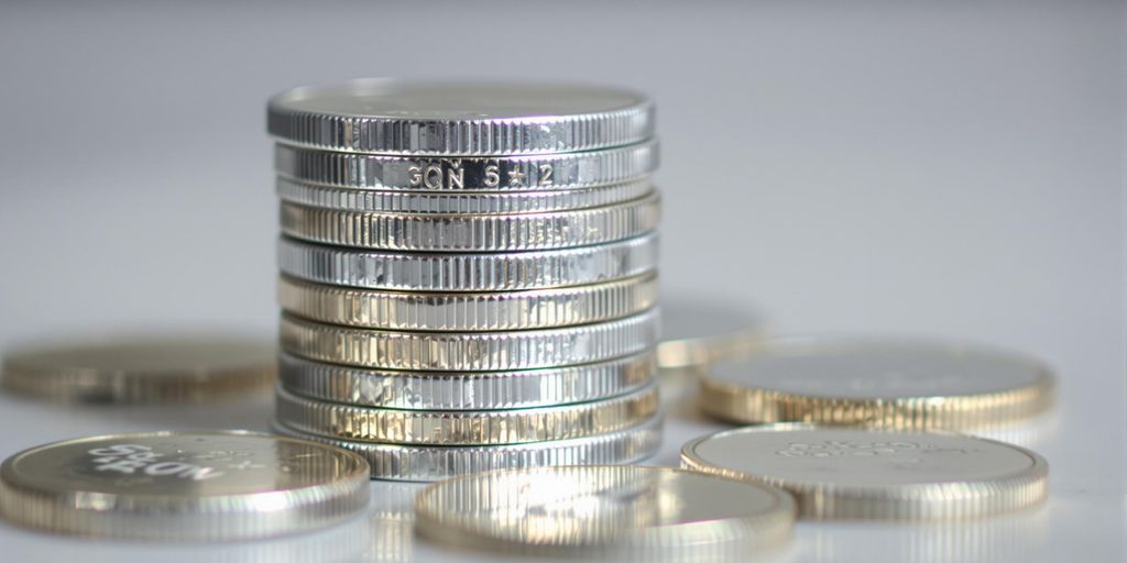 Pièces d'argent brillantes empilées et dispersées.