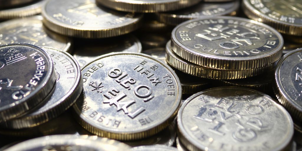 Pièces d'argent brillantes empilées, certaines avec des marques douanières.