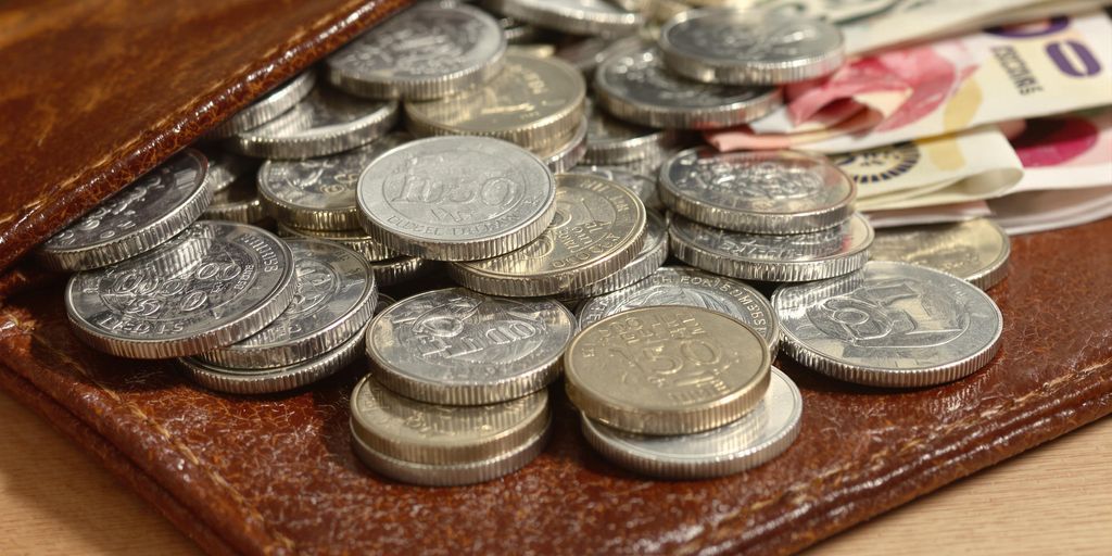 Portefeuille rempli de pièces d'argent et de billets de banque.