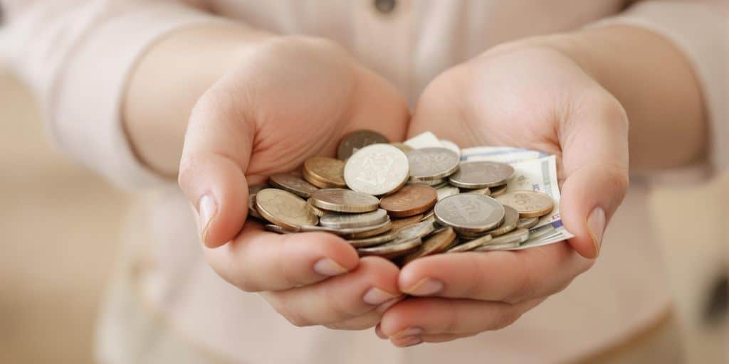Main tenant des pièces de monnaie et des billets de banque.