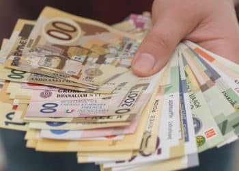 Main tenant des billets de banques étrangers.