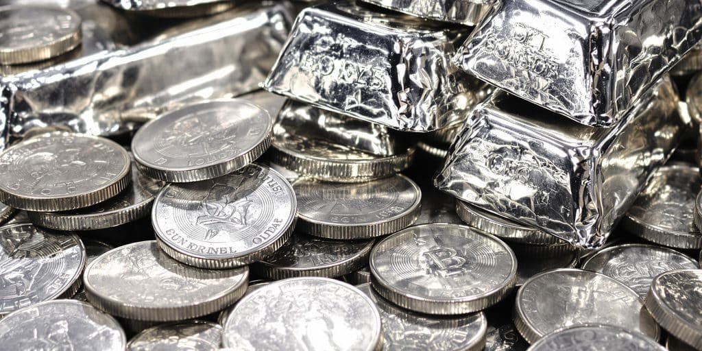 Lingots d'argent et pièces anciennes empilés.
