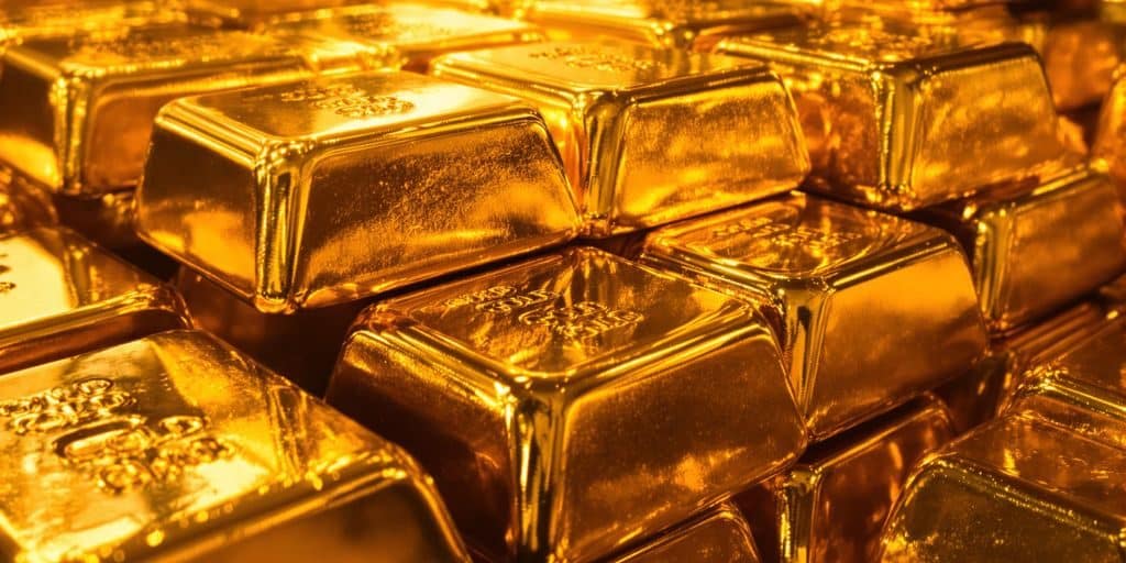 Lingots d'or brillants scintillant sous une lumière dorée.