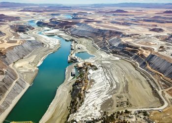 Une rivière traverse un paysage minier, reliée à des infrastructures.