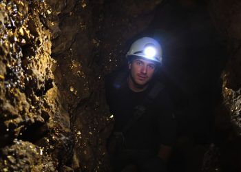 Mineur dans une galerie d'or avec équipement.