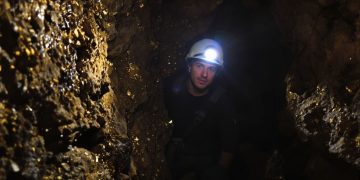 Mineur dans une galerie d'or avec équipement.