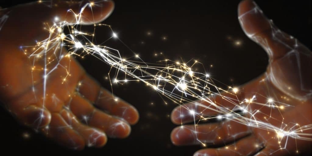 Deux mains se touchant avec des lumières numériques abstraites.