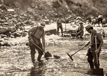 Prospecteurs d'or creusant dans une rivière rocailleuse.