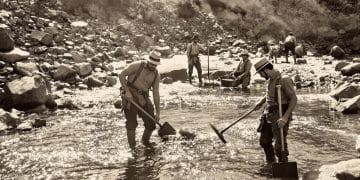 Prospecteurs d'or creusant dans une rivière rocailleuse.