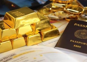 Lingots d'or et passeport sur une table.