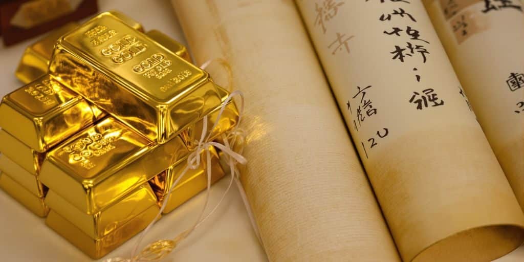 Lingots d'or brillants et parchemins japonais anciens.