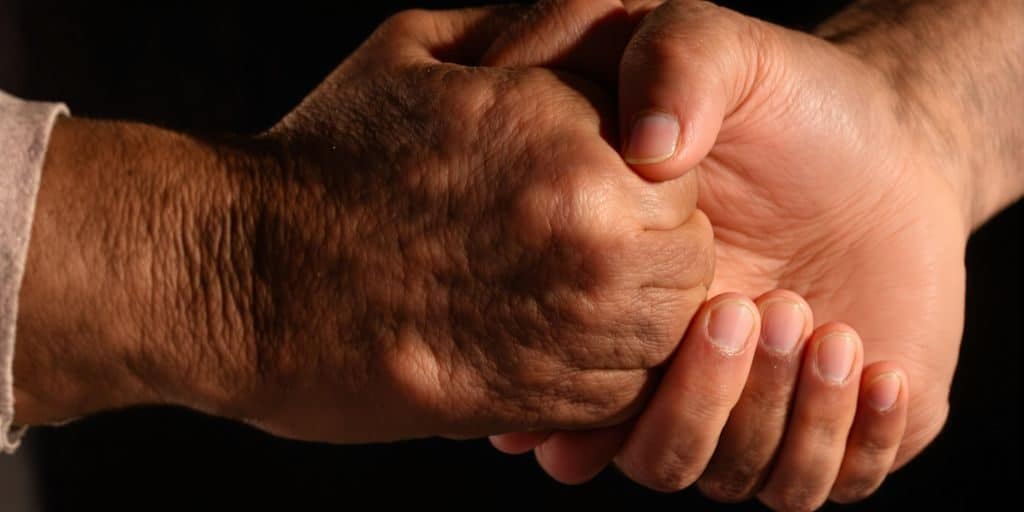 Deux mains se serrent fermement dans un geste de confiance.